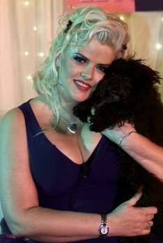 Smith poses, with her black toy poodle Sugar Pie, in 2002 during a media presentation of E! Networks The Anna Nicole Smith Show. Photo: DAMIAN DOVARGANES, Associated Press
