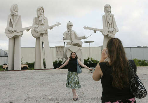 Liz Dannemiller poses for Anna Schumann in front of David Adickes' Beatles statues Thursday at his SculpturWorx Studio on Summer near Interstate 10 and Taylor. Photo: Kevin Fujii, Chronicle
