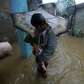 A man carries a child along a flooded street during typhoon Nesat.... photo: 1630334 slideshow 31095