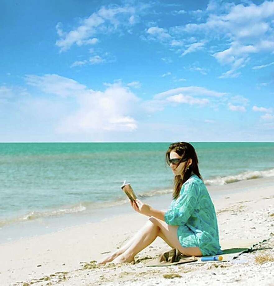 Leitura da mulher na praia.  Foto: Shutterstock.com