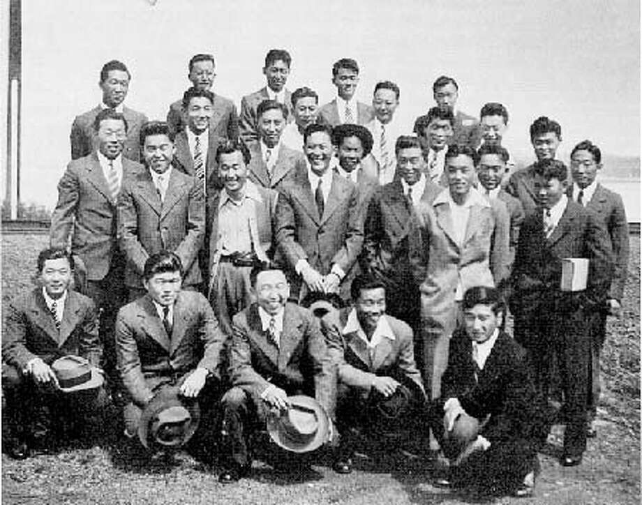 Heart Mountain resisters pose in prison-issued suits on July 14, 1946, the day of their release from McNeil Island. Yosh Kuromiya stands in the back row, second fromthe left. Photo Courtesy Yosh Kuromiya.