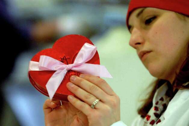 Nikki Dragon, an employee at Krause&#39;s Homemade Candy in Colonie, puts a ribbon on - 628x471