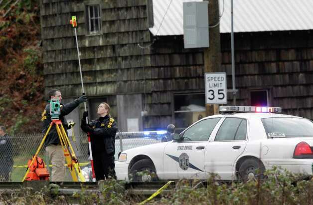 Washington State Patrol officials investigate the scene where a state 