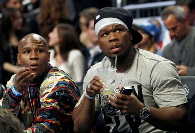 Boxer Floyd Mayweather Jr, left, and performer 50 Cent sit courtside during the NBA All-Star Shooting Stars basketball competition in Orlando, Fla., Saturday, Feb. 25, 2012. (AP Photo/Lynne Sladky) (AP) / SA