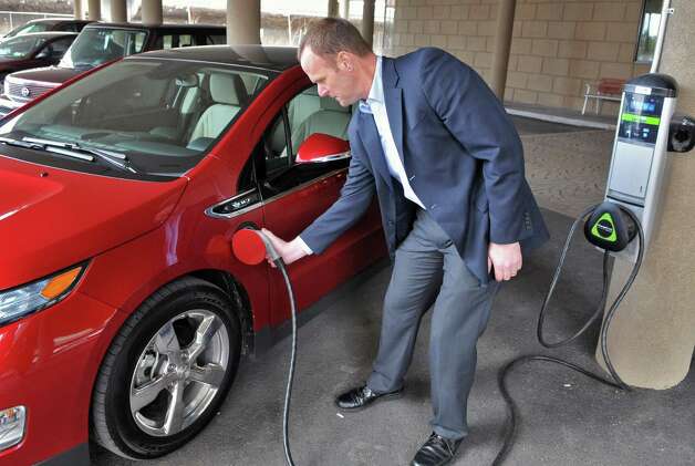 General Motor's Stephen Marlin demonstrates using a public recharging