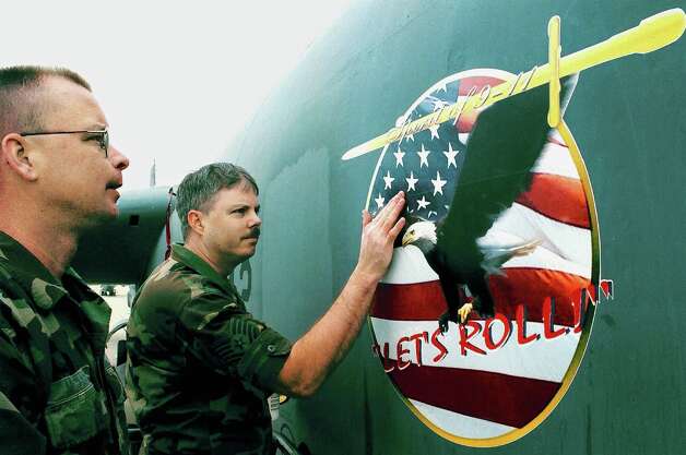 U.S. Air Force Reservists Tech. Sgt. Ron (left) and Staff Sgt. Brian of the 93rd Bomber
 Squadron apply a decal with the phrase "Lets Roll" to the side of a B-52 bomber on Feb. 20, 2002 at Barksdale Air Force Base, La.
 Photo: Mario Villafuerte, Getty Images / Getty Images North America