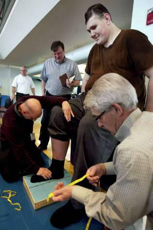 Igor Vovkovinskiy, of Minneapolis, currently the tallest man in the United States at seven feet eight inches, has an imprint taken of his foot by technicians as part of a shoe fitting at Reebok headquarters, in Canton, Mass., Thursday, May 3, 2012. Vovkovinskiy, who has a shoe size between 22 and 26, says he's had 16 surgeries in six years to fix problems created by shoes that didn't fit. Reebok is providing the shoes at no charge. (AP Photo/Steven Senne) Photo: Steven Senne / AL