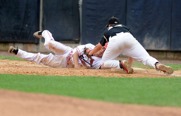 Greenwich's Ricky Okazaki dives back to first base as he id tagged by Trumbull's Carl Johnson during Saturday's FCIAC baseball championship game at the Ballpark at Harbor Yard in Bridgeport on May 26, 2012. Photo: Lindsay Niegelberg / Stamford Advocate