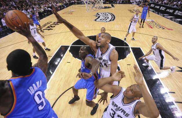Oklahoma City Thunder's Serge Ibaka (9) passes under pressure from San Antonio Spurs' Tim Duncan (21) during the first half of game two of the NBA Western Conference Finals in San Antonio, Texas on Tuesday, May 29, 2012. Edward A. Ornelas/Express-News (Edward A. Ornelas / San Antonio Express-News) / SA