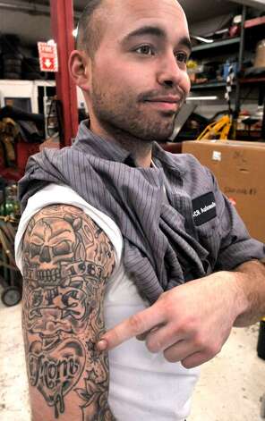 Brian Cusack of Danbury displays his tattoo at work at Alley Cat Racing in