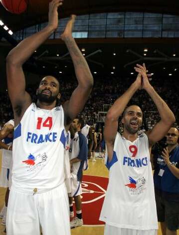 French NBA players Tony Parker, right, and Ronny Turiaf applaud after their Euro 2009 basketball qualifying round France against Belgium, in Pau, southwestern France, Sunday, Aug. 30, 2009. France won 92 to 54 to qualify. (Fred Scheiber / Associated Press) / SA