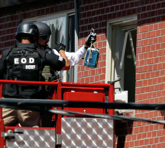 Members of law enforcement prepare to place what ATF sources describe as a "water shot" in the apartment of alleged Aurora, Colo., gunman James Holmes. The "water shot" is placed near an IED and explodes. The blast is used to disable the IED. Photo: Alex Brandon / AP