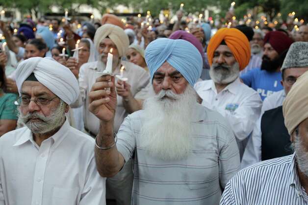 A crowd of people raise their candles during vigil Thursday, Aug. 9, 2012, in Houston  at the reflection pool at City Hall to remember the victims of the Sikh temple shooting in Wisconsin. Photo: Melissa Phillip, Houston Chronicle / © 2012 Houston Chronicle