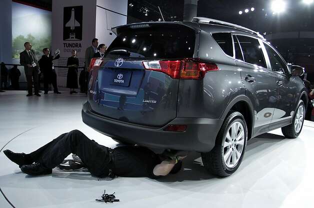 An employee checks underneath the 2013 Toyota Motor Corp. RAV4 crossover vehicle during the LA Auto Show in Los Angeles, California, U.S., on Wednesday, Nov. 28, 2012. Toyota Motor Corp., headed for its best U.S. sales in four years, wants to boost deliveries next year of its RAV4 by 18 percent as it pits a restyled version of the crossover against rivals Honda Motor Co. and Ford Motor Co. Photo: Jonathan Alcorn, Bloomberg / SF
