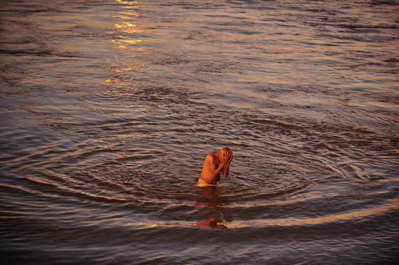 An Indian devotee takes a holy dip at the Sangam during the Maha Kumbh festival in Allahabad on Febr