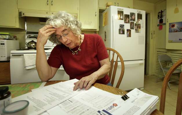Carol Patterson reviews records on energy improvements she made to her home. The projects earned her about $2,000 credit on her CPS Energy bills. Photo: Bob Owen / San Antonio Express-News