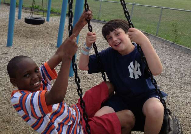 Donte McKenzie, a 9-year-old boy from Brooklyn, N.Y., and Tobey Sappern play on a tire swing last summer on the playground at Fairfield's Roger Sherman Elementary School. The Sappern family of Fairfield hosted McKenzie for a week last August through the Fresh Air Fund program and plan on taking him again for another week this August. Photo: Contributed Photo