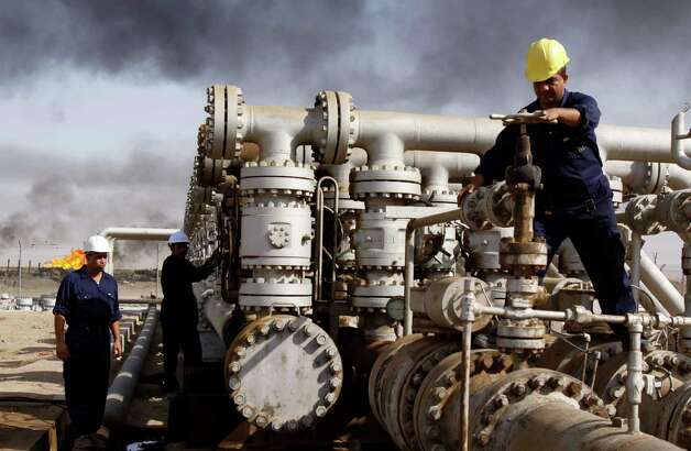 FILE - In this Dec. 13, 2009 file photo, Iraqi laborers work at the Rumaila oil refinery, near the city of Basra. A senior Iraqi official on Wednesday said his country expects to ramp up oil production to 4.5 million barrels per day by the end of next year from around 3.5 million barrels now, thanks to work by a handful of international oil companies developing the country’s prized oil and gas fields. (AP Photo/Nabil al-Jurani, File) Photo: Nabil Al-Jurani