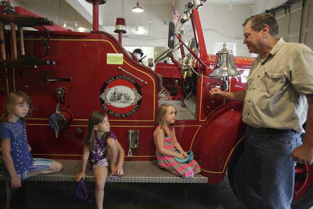 Al Michalczak, who worked for the Fire Department for 33 years, talks to sisters Taylor, 8, Lainey, 6, and Sophia Sloan, 5. Photo: Abbey Oldham / San Antonio Express-News