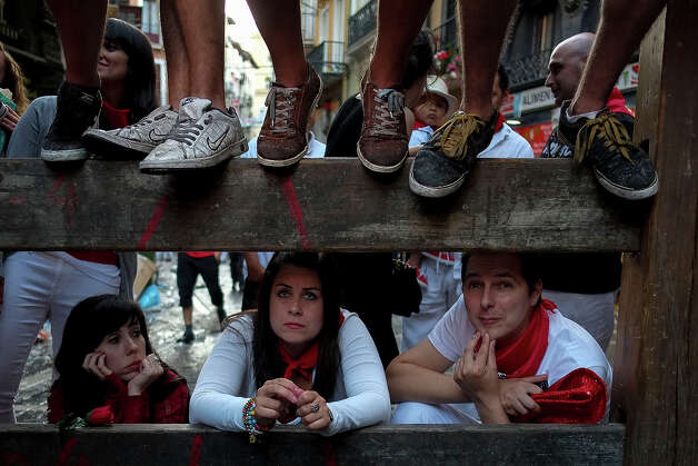 People watch the first bull run of the San Fermin Festival, on July 7, 2013, in Pamplona, northern Spain. The festival is a symbol of Spanish culture that attracts thousands of tourists to watch the bull runs despite heavy condemnation from animal rights groups. Photo: PEDRO ARMESTRE, AFP/Getty Images / 2013 AFP