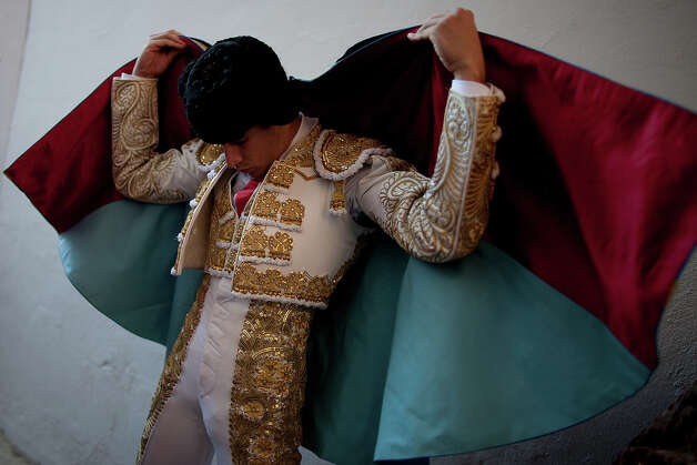 Bullfighter Alberto Lopez Simon puts on his capote before performing with Alcurrucen's fighting bulls in the bullring during the second day of the San Fermin Running Of The Bulls festival on July 7, 2013 in Pamplona, Spain. The annual Fiesta de San Fermin, made famous by the 1926 novel of US writer Ernest Hemmingway 'The Sun Also Rises', involves the running of the bulls through the historic heart of Pamplona, this year for nine days from July 6-14. Photo: Pablo Blazquez Dominguez, Getty Images / 2013 Getty Images
