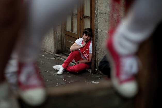 A reveller rests in the early hours ahead of Dolores Aguirre's ranch fighting bulls running at Curva Estafeta on the third day of the San Fermin Running Of The Bulls festival, on July 8, 2013 in Pamplona, Spain. The annual Fiesta de San Fermin, made famous by the 1926 novel of US writer Ernest Hemmingway 'The Sun Also Rises', involves the running of the bulls through the historic heart of Pamplona for nine days from July 6-14. Photo: Pablo Blazquez Dominguez, Getty Images / 2013 Getty Images