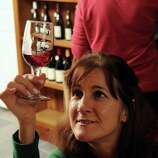 <b>Katherine Arbiter</b> examines a glass of wine before sampling it at the new ... - square_gallery_thumb