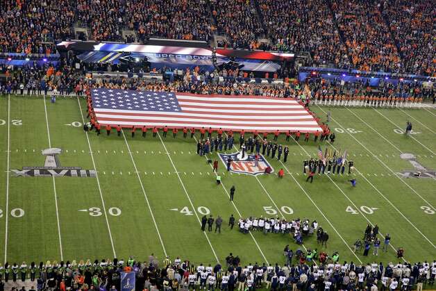 Image of the American flag on a football field. 