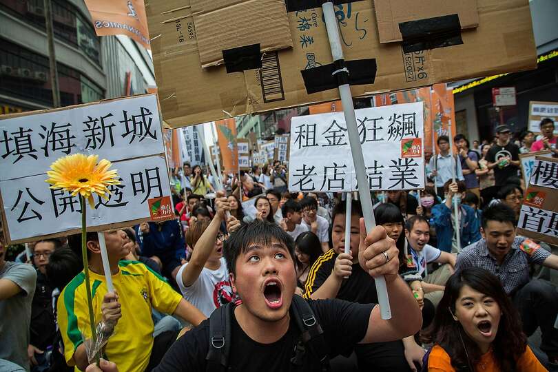 Protesters shout slogans and hold banners during a May Day demonstration on May 1, 2014 in Macau, Ch