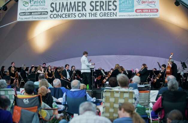 Music lovers take in a performance by the Danbury Symphony Orchestra, directed by Ariel Rudiakov, on the Danbury Green on June 18, 2011. This year, on June 14 at 7:30 p.m., the Danbury Symphony Orchestra will open CityCenter’s Summer Concerts on the Green series with a pop music program called “Heroes & Villains.” Photo: Scott Mullin, ST / The News-Times Freelance