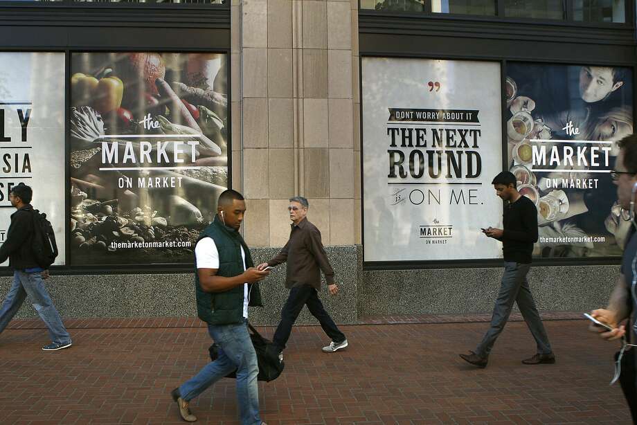 Pedestrians walk outside the new locally owned grocery store named Market on Market on the first floor of the Twitter building  in San Francisco, Calif., on Thursday, October 23, 2014.  Under construction Market on Market is scheduled to open by the holidays. Photo: Liz Hafalia, The Chronicle