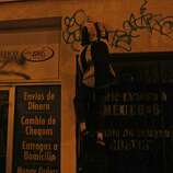 A man paints a building with graffiti during a riot near 22nd and Mission after the San Francisco Giants win the World Series against the Kansas City Royals Wednesday, October 29, 2014.