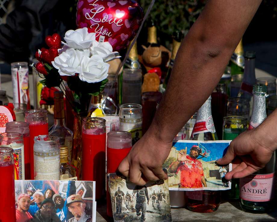 Alex Montano straightens out a photo of Dominic Newton, 37, at the site of the incident near 94th Avenue and MacArthur Boulevard, Tuesday, Feb. 3, 2015, in Oakland, Calif. Newton was a Bay Area rapper known by his stage name "The Jacka" who was shot and killed Monday night. Photo: Santiago Mejia, The Chronicle