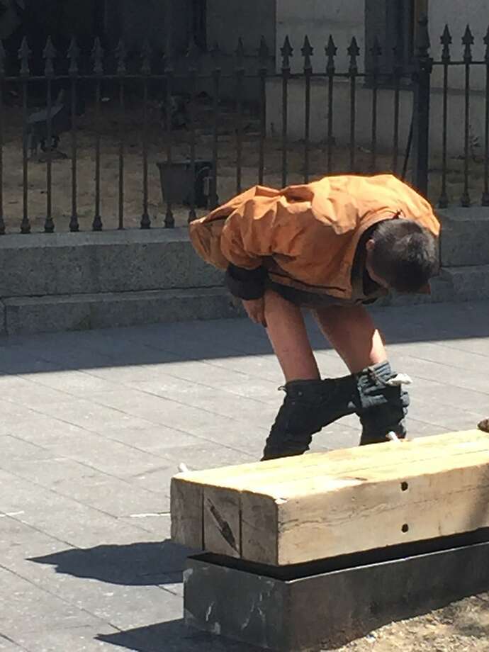 A homeless man squats to defecate at Mint Plaza, just off 5th Street, on Aug. 17 Photo: M&r, Andrew Ross, SF Chronicle