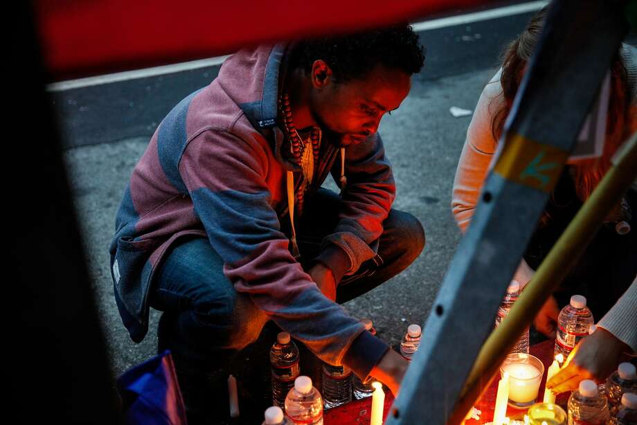 Fikre Atnafe lights candles at a vigil for Yonas Alehegne, an Ethiopian immigrant he knew who was shot and killed by an Oakland police officer in August, in Oakland, Calif., on Sunday, September 13, 2015. Photo: Sarah Rice, Special To The Chronicle