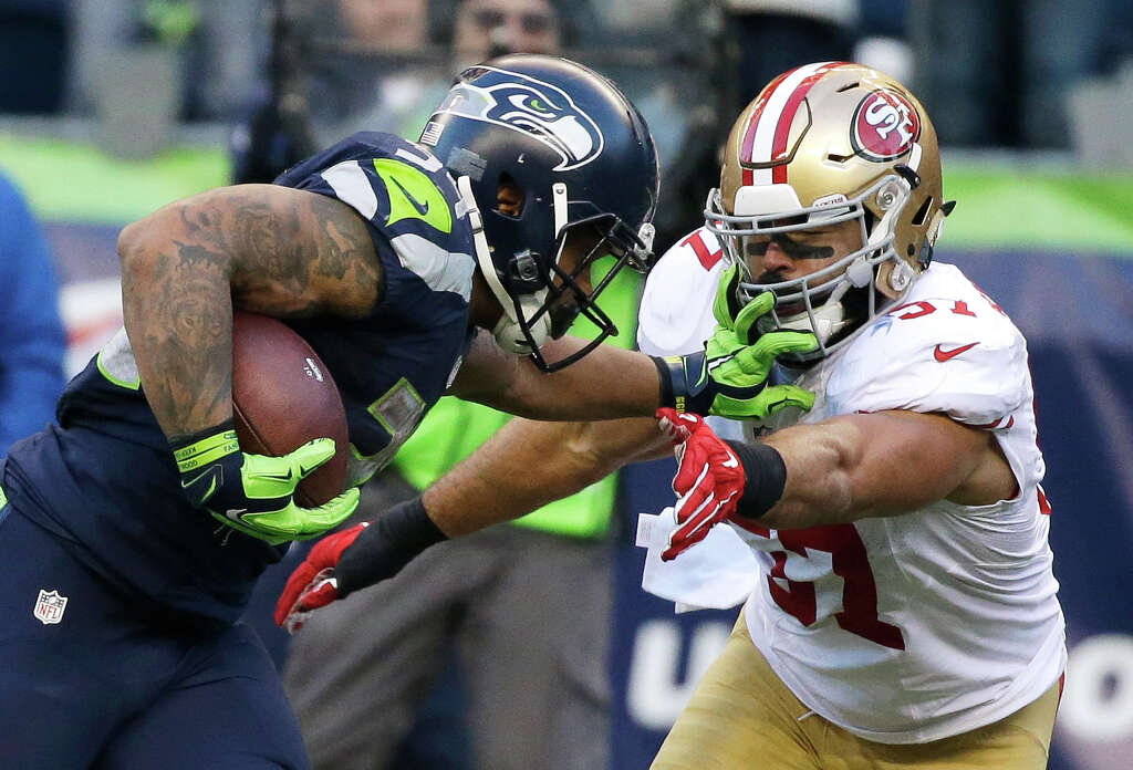 Seattle Seahawks running back Thomas Rawls, left, pushes off San Francisco 49ers inside linebacker Michael Wilhoite, right, as he runs for a touchdown during the second half of an NFL football game, Sunday, Nov. 22, 2015, in Seattle. (AP Photo/Elaine Thompson) Photo: Elaine Thompson, Associated Press / AP
