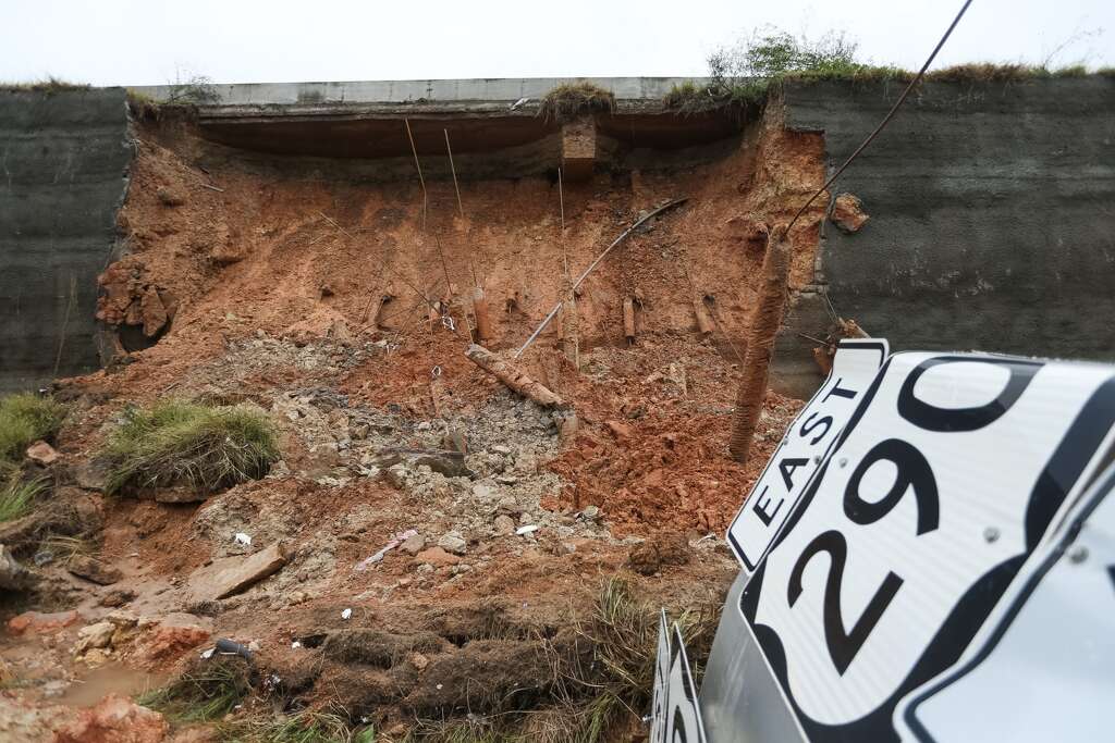 Edgar Peneda, of Roadway Construction, takes photos along the feeder road where the East bound 290, at Huffmeister, retention wall has collapsed.