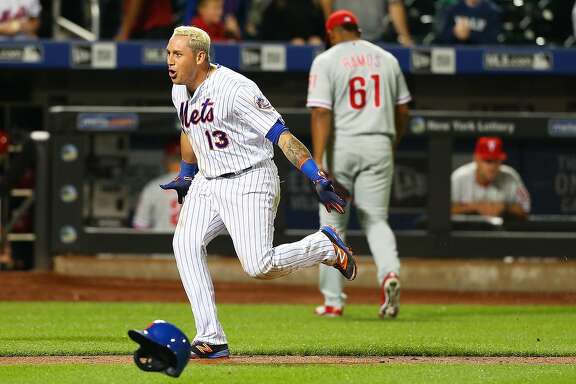 NEW YORK, NEW YORK - SEPTEMBER 22:  Asdrubal Cabrera #13 of the New York Mets celebrates after hitting a game winning walk-off three run home run in the bottom of the twelfth inning against as Edubray Ramos #61 of the Philadelphia Phillies walks off the field at Citi Field on September 22, 2016 in the Flushing neighborhood of the Queens borough of New York City.  (Photo by Mike Stobe/Getty Images)