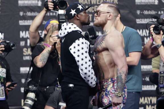 Floyd Mayweather Jr. (left) and Conor McGregor face each other for photos during a news conference at Barclays Center in New York on July 13, 2017.