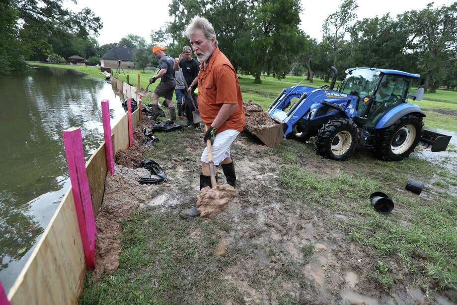 Keith Bailey helps shore up the levee of the Varner Creek in the Columbia Lakes subdivision in West Columbia on Tuesday. Photo: Steve Gonzales, Staff / © 2017 Houston Chronicle