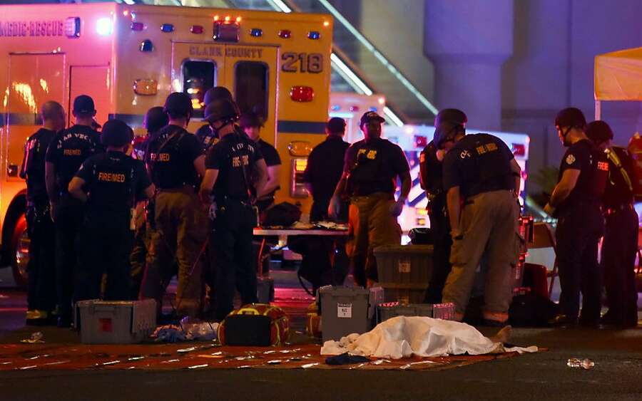 A body lies under a sheet as fire and rescue personnel gather at the intersection of Las Vegas Boulevard and Tropicana Avenue after a mass shooting at a country music festival nearby on October 1st, 2017, in Las Vegas, Nevada.  Photograph: Ethan Miller/Getty Images.