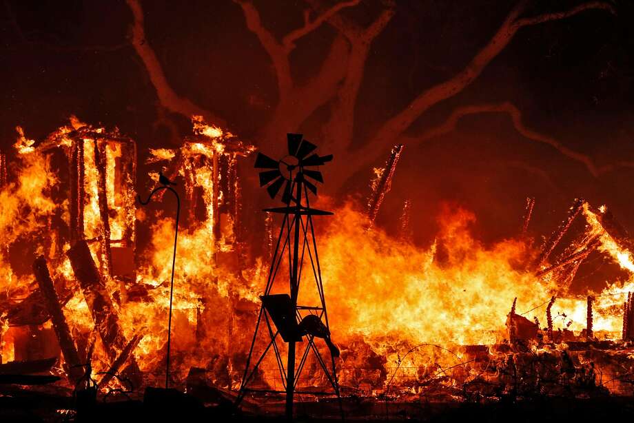 A structure fire burns behind an ornamental windmill as a wild fire burned on Soda Canyon Road in Napa, Calif., on Monday, October 9, 2017. Photo: Carlos Avila Gonzalez, The Chronicle