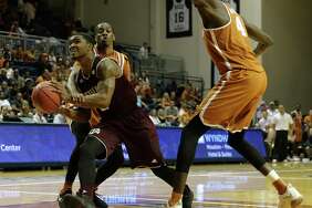 Texas A&M Aggies guard TJ Starks (2) is fouled by Texas Longhorns guard Matt Coleman (2) on the way to the basket in the second half during the exhibition basketball game between the Texas Longhorns and the Texas A&M Aggies to benefit the Rebuild Texas Relief Fund at Tudor Fieldhouse in Houston, TX on Wednesday, October 25, 2017.