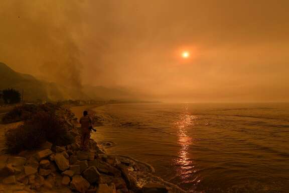 Heavy smoke covers the seaside enclave of Mondos Beach beside the 101 highway as flames reach the coast during the Thomas wildfire near Ventura, California on December 6, 2017. California motorists commuted past a blazing inferno Wednesday as wind-whipped wildfires raged across the Los Angeles region, with flames  triggering the closure of a major freeway and mandatory evacuations in an area dotted with mansions. / AFP PHOTO / MARK RALSTONMARK RALSTON/AFP/Getty Images
