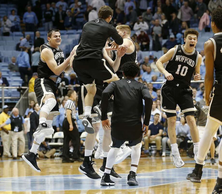 Wofford players including Fletcher Magee (far left) and Nathan Hoover (10) celebrate after the Terriers beat fifth-ranked North Carolina 79-75. Photo: Ellen Ozier, Associated Press