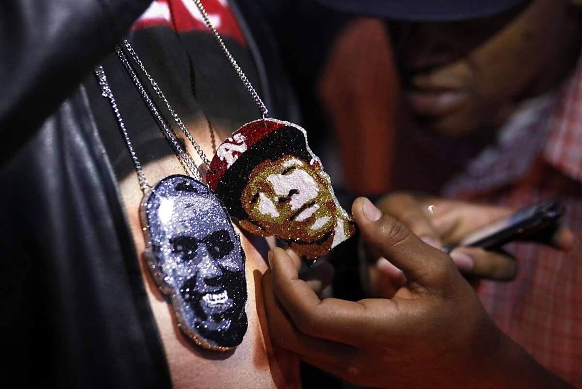 Saturday February 16, 2013, at a candlelight vigil marking the one year anniversary of the death of his son, Ramon Price Sr. displays the necklaces that he had made with the face of Lamont and the face Damian Williams, both who were killed on the streets of Oakland, Calif. Photo: Lacy Atkins, The Chronicle