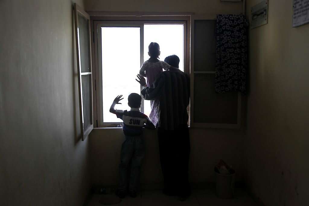 Surrogate Manisha Parmar's husband, Raman (right), daughter, Urvashi, 3, and son, Tanvay, 8, wait in the hall outside her room at the Akanksha Infertility Clinic in Anand, India, Thursday, May 23, 2013.  Parmar gave birth later that day. Photo: Nicole Fruge, The Chronicle