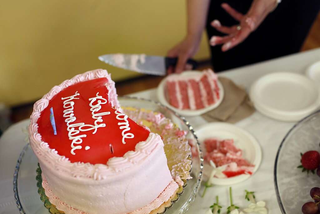 Jennifer Benito-Kowalski's sister Lourdes Benito-Goodall cuts the cake during a baby shower at Fairbrae Swim and Racquet Club in Sunnyvale, Calif., on Saturday, April 6, 2013. After years of trying to conceive, the Kowalskis paid a surrogate in India to carry their child. Photo: Nicole Fruge, The Chronicle