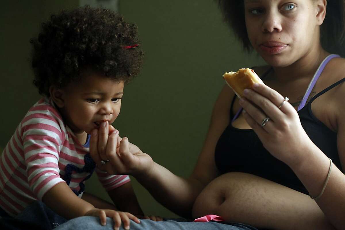 Brijjanna Price gives her daughter LaMya Deshana Price a bite of her lunch as they watch television, Wednesday, November 6, 2013, in Hayward, Calif. Photo: Lacy Atkins, The Chronicle