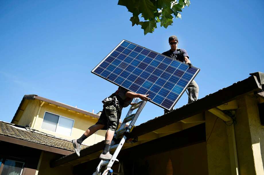 Brandon Anderson and Will LaRocque of Sunrun install solar panels on a home in Sunnyvale. Photo: Michael Noble Jr., The Chronicle